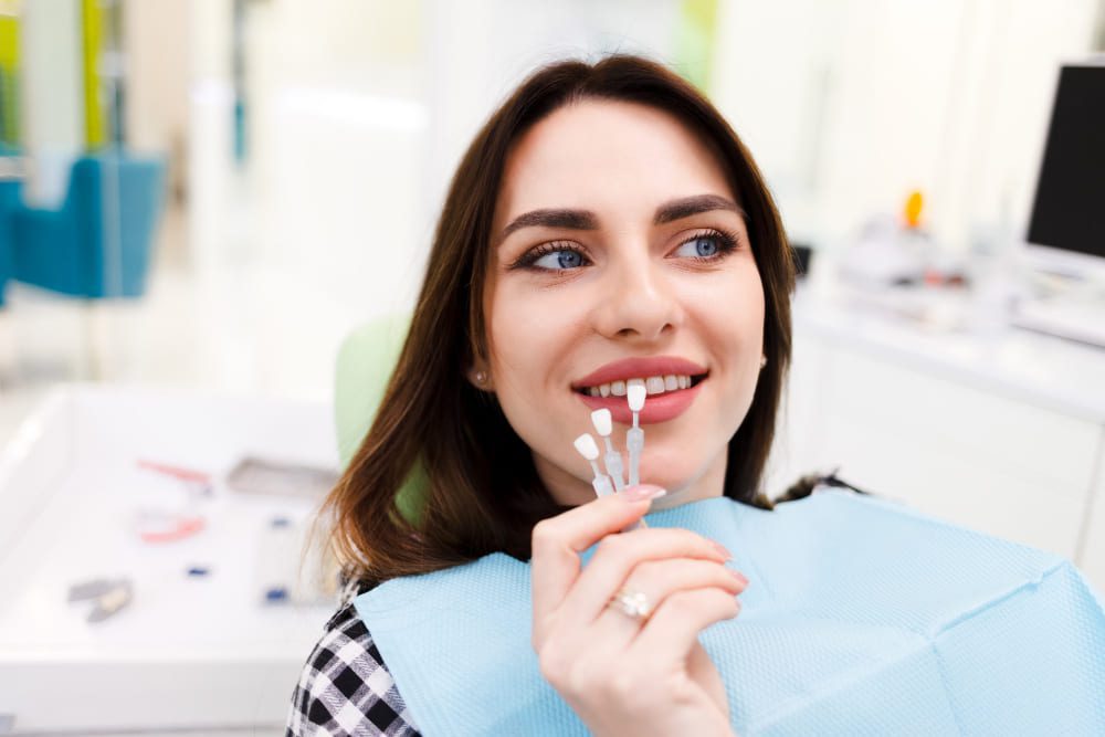 mulher escolhendo a cor para facetas de porcelana