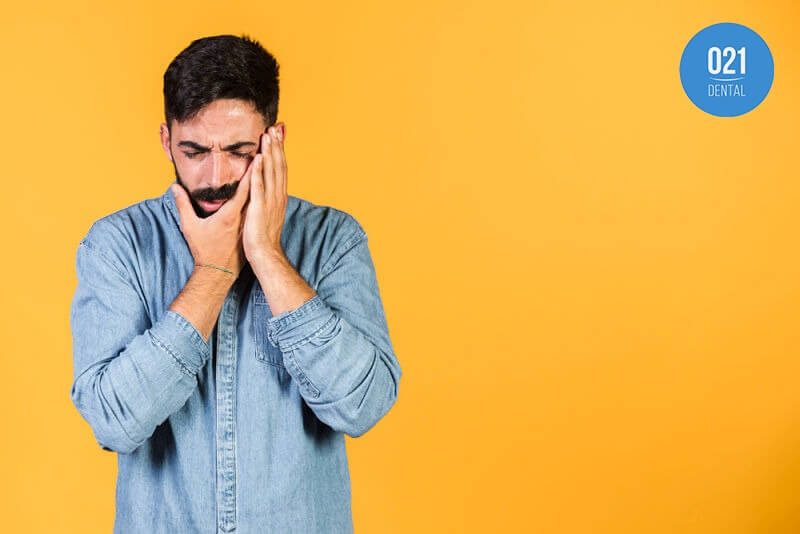 Homem sentindo dor mandibular causada por bruxismo