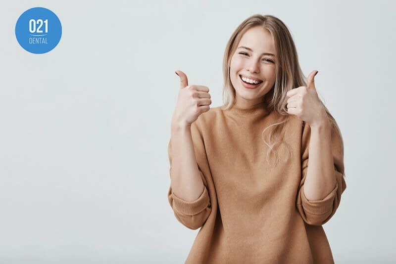 mulher sorrindo e fazendo gesto positivo com as mãos