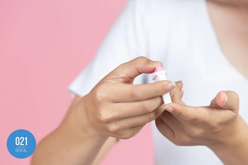 Mulher medindo o nível de açúcar no sangue com furo nos dedos