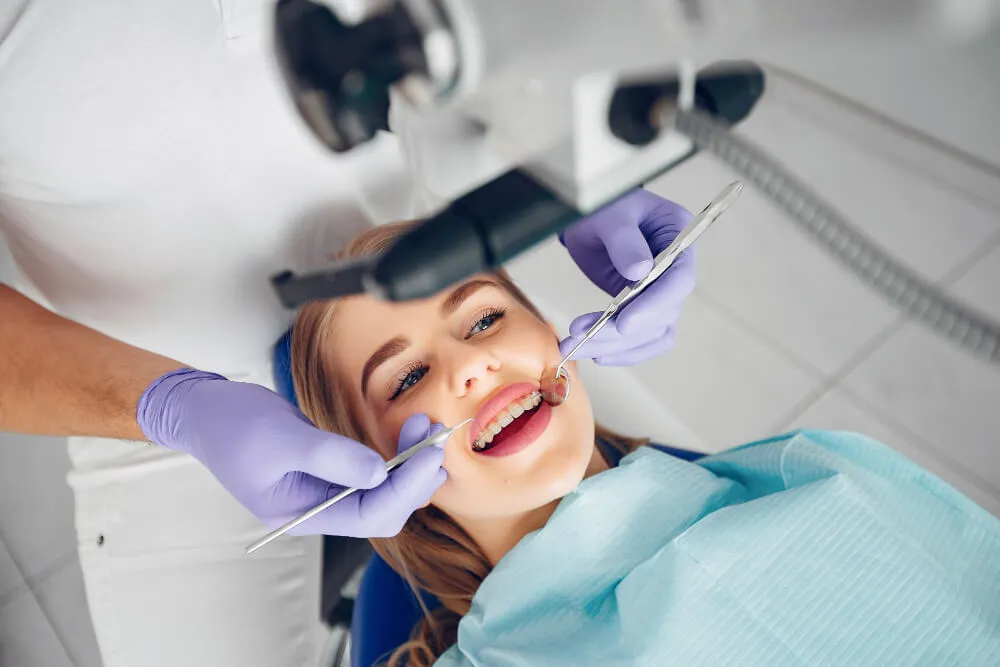 Mulher loira sendo atendida por um dentista